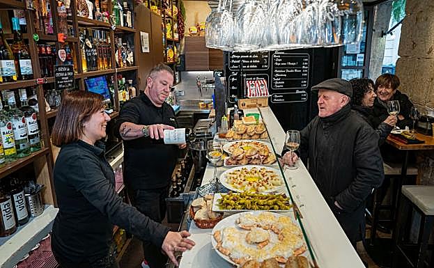 David Pérez y Eva Rivero atienden a un parroquiano del Orain